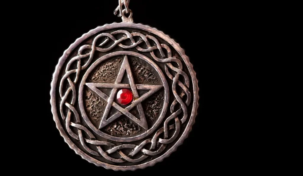 Amulet z pentagramem i czerwonym magicznym kamieniem ochronnym