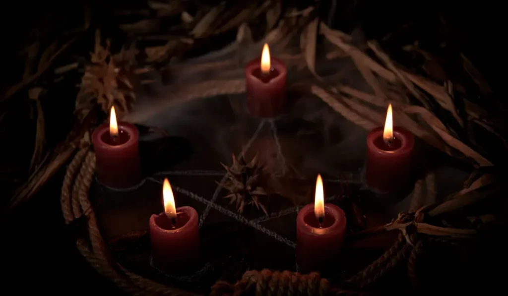 Magiczne świece ułożone na pentagramie, przygotowanie do rytuału rzucenia klątwy rodowej